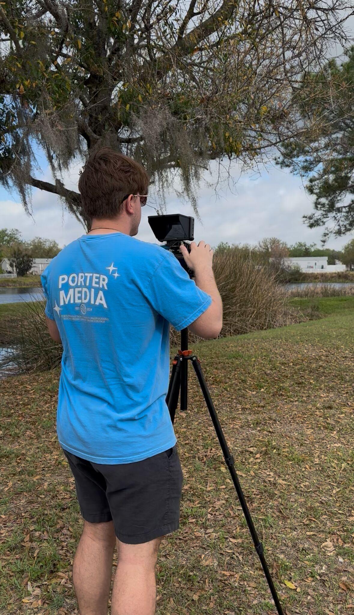 Garrett Porter setting up a camera on a tripod by a pond for a client shoot