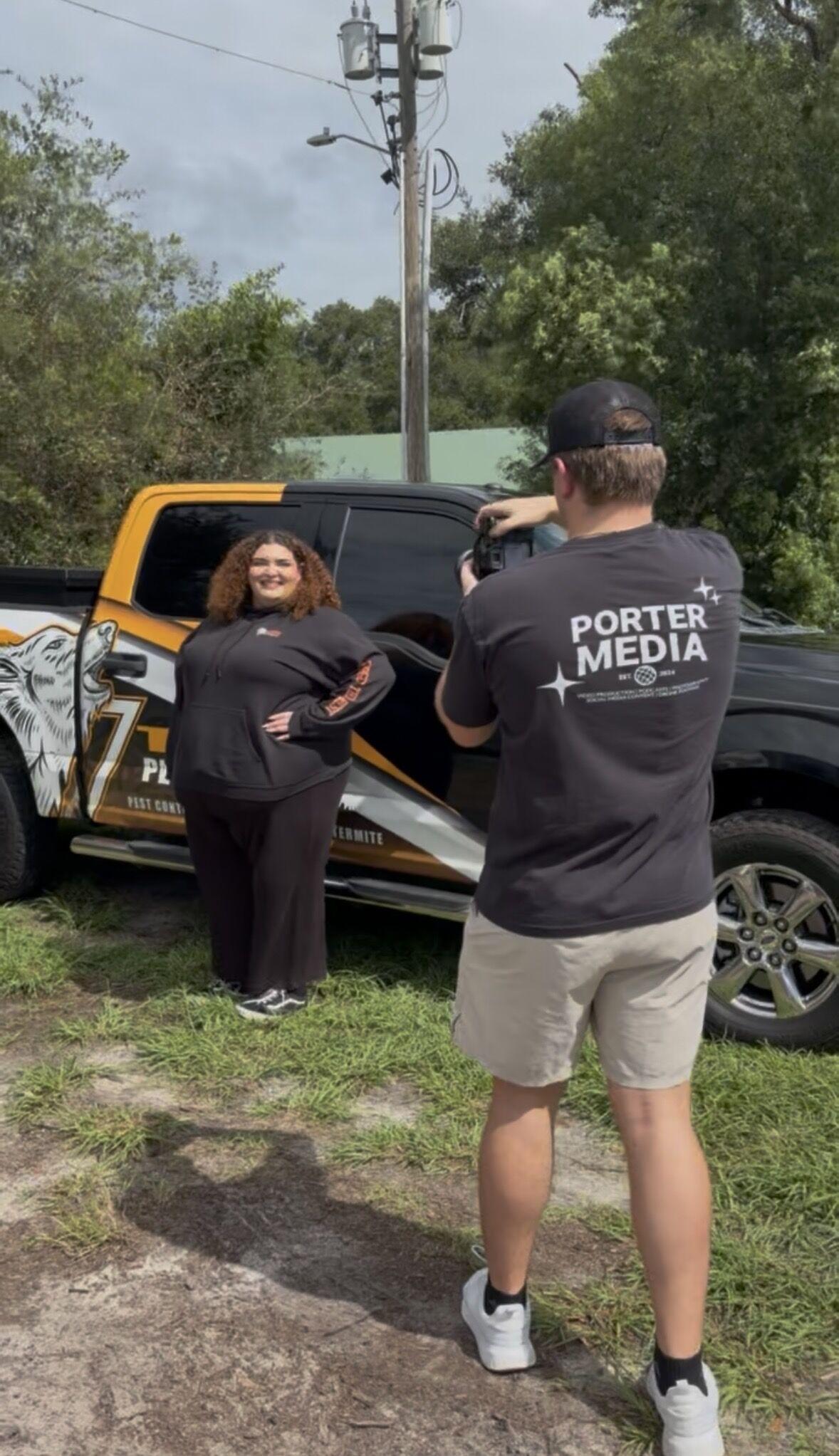 Garrett Porter photographing a client in front of her wrapped work truck